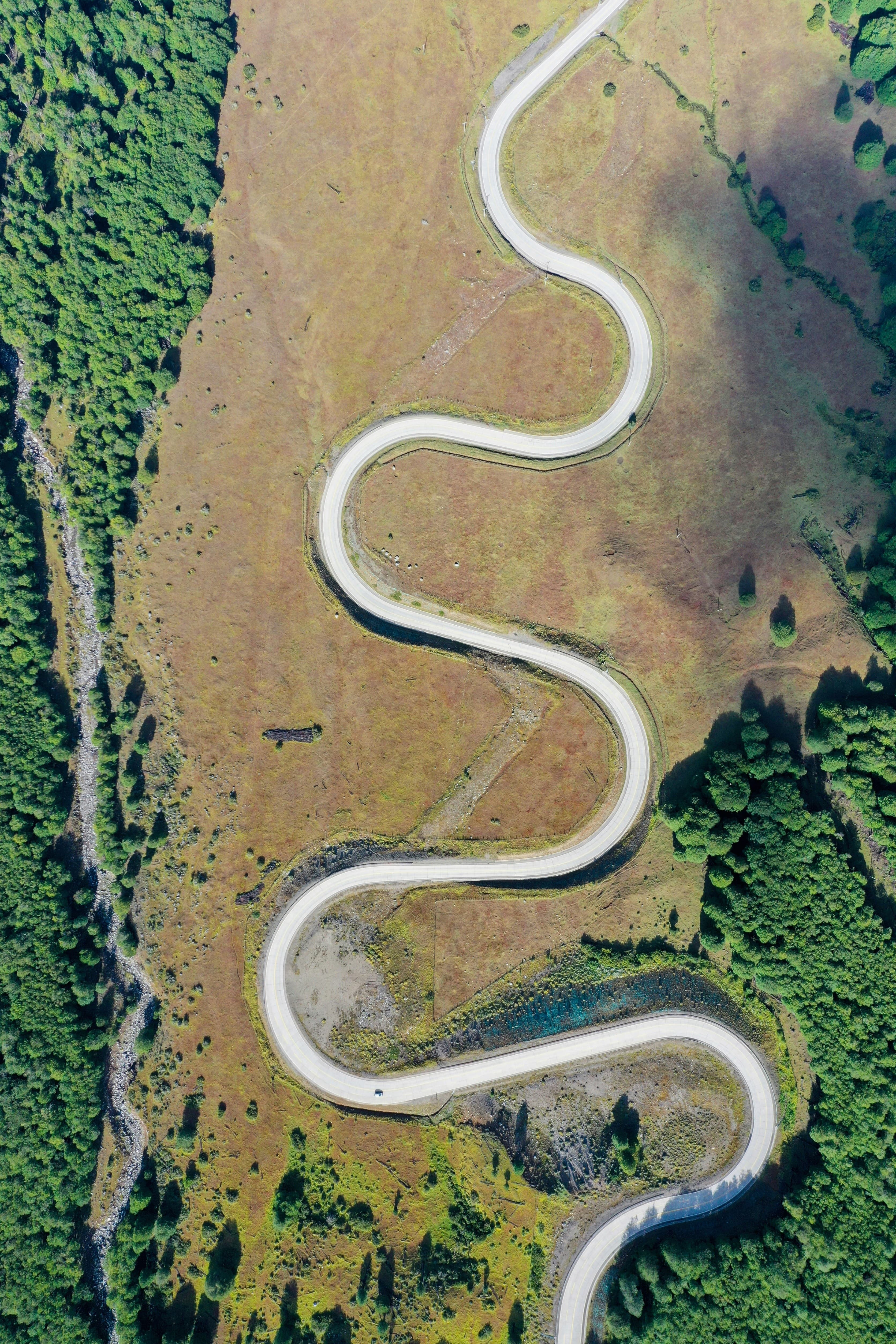 Aerial view of a winding road through a valley, the guest's route staying in one hotel's hands end to end